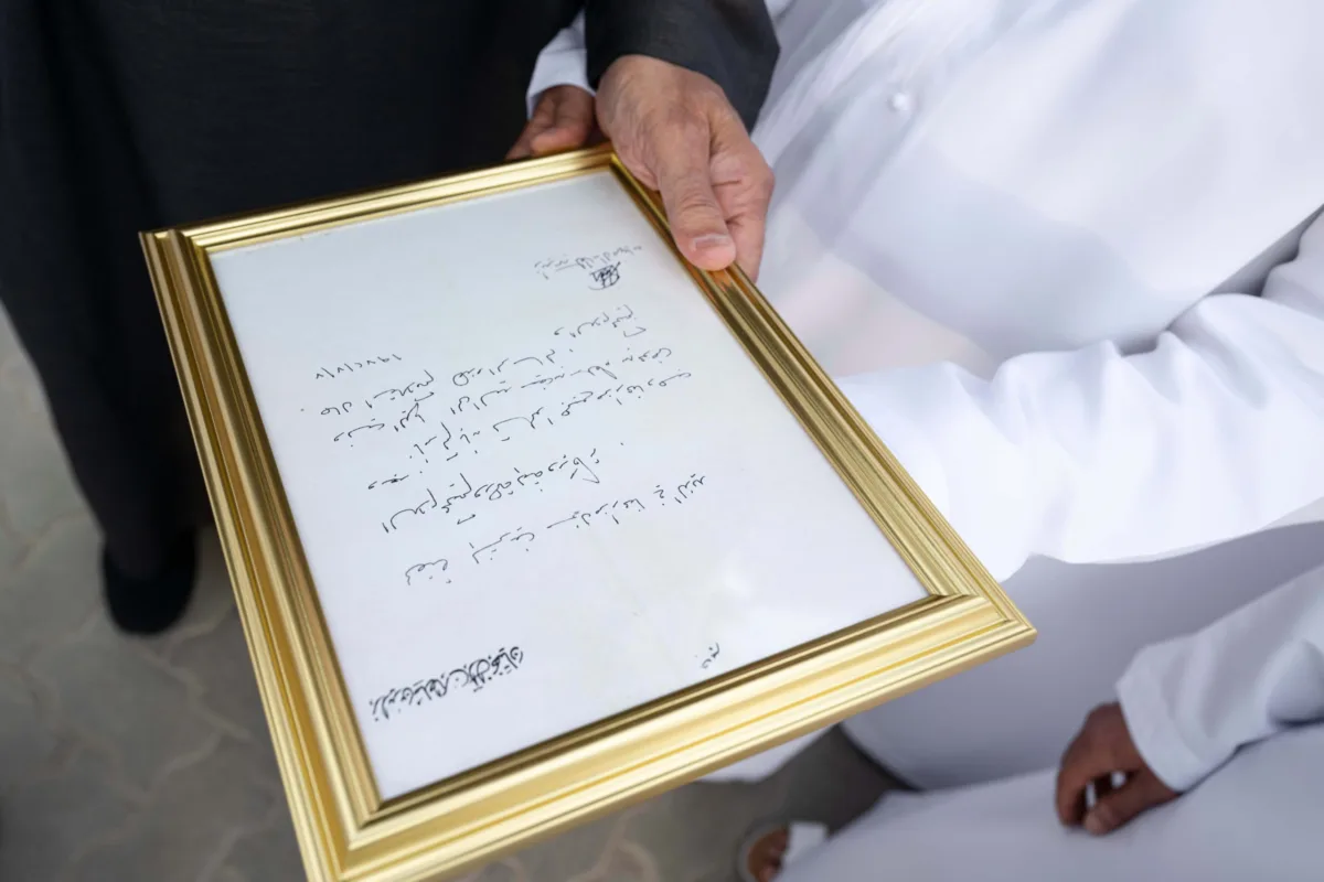 صاحب السمو الشيخ محمد بن زايد آل نهيان، رئيس دولة الإمارات، يلتقي أفراد عائلة الصيري القمزي خلال مناسبة رسمية في الهواء الطلق، محاطًا بعدد كبير من الرجال والنساء والأطفال بملابسهم الوطنية، تكريمًا لدور العائلة في الإشراف على مزرعة الشيخ زايد في الخوانيج.